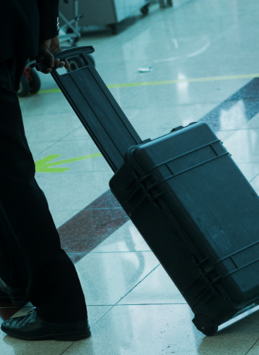 Man walking in an airport wheeling a black hardcase
